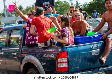  BANG NIANG, THAILAND - APRIL 13, 2018:  Thai locals in pickup trucks celebrate the new year Songkran festival by throwing water onto passers by