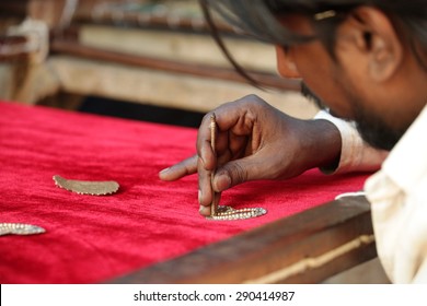 Bangalore, Karnataka, India - March 20, 2014: Unidentified craftsman embroidering cloth in traditional method of India.