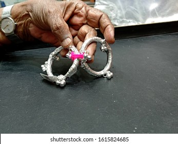 Bangalore/India, January 15,2020. Elderly Woman Holding Silver Jewelry To Buy As A Present. Silver Baby Size Anklet Jewelry. Silver Gift Is Given In Auspicious Function Like Naming Ceremony.