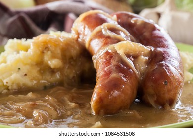 Bangers And Mash. Baked Sausage In Onion Gravy Served With Mashed Potatoes