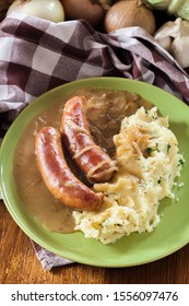 Bangers And Mash. Baked Sausage In Onion Gravy Served With Mashed Potatoes. Top View