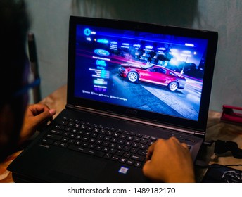 Bangi, Malaysia - August 28, 2019: Young student stay up late during the night playing video games on the gaming laptop. Sleeping and time management problems.