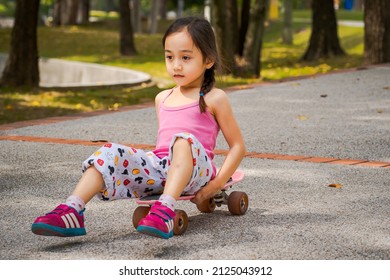 Bangi, Malaysia - Jan 25, 2022 Motion Of A Child Riding Skateboard In The Park. Little Girl Learning To Ride Skate Board.