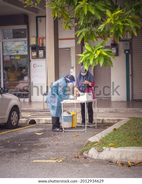 Bangi, Malaysia - July 13 2021\
Health worker performing COVID-19 sampling taken from individuals\
by drive thru at the Quick Test Kit Program from a local\
clinic.