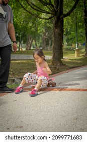 Bangi, Malaysia - Oct 16, 2021 Child Riding Skateboard In The Park. Little Girl Learning To Ride Skate Board.