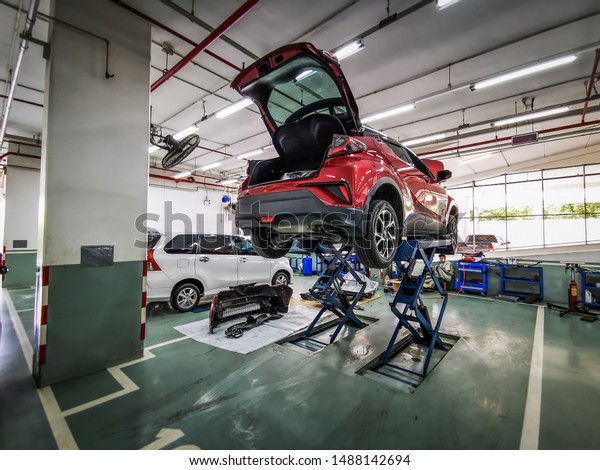Bangkok 26/8/2519, car repair and auto inspection,\
Toyota service center, red cars C-HR On the car lift is waiting for\
the technician to check