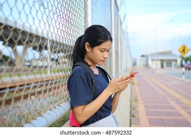 Bangkok ,31 August 2016 : Young Asia Girl Playing Smart Phone At Train Station ,evening Time