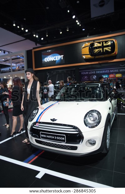 BANGKOK - April 5, 2015 : Unidentified\
model with Mini car on display at The 36th Bangkok International\
Motor show on April 5, 2015 in Bangkok,\
Thailand.
