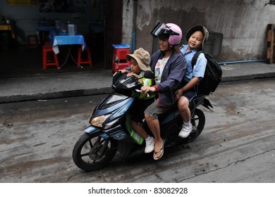 BANGKOK - AUG 16: Unidentified Family School Run On A Motorbike During The Morning Rush Hour On Aug 16, 2011 In Bangkok, Thailand. The Use Of Motorbikes As Family Transport Is Commonplace In Thailand.