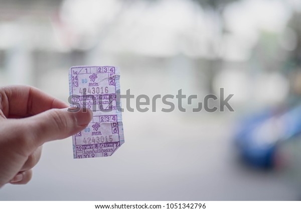 Bangkok bus ticket in hand with beside the road\
meaning of price 6.50\
baht.