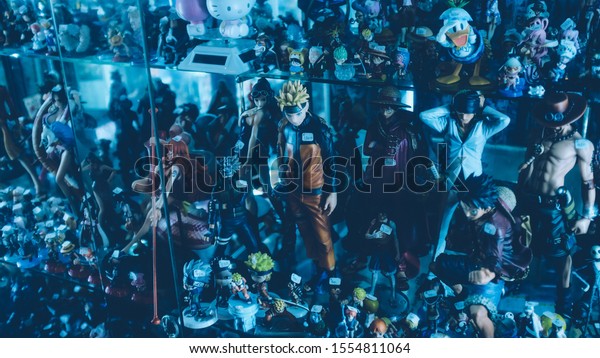 Bangkok,\
Central Thailand/Thailand - May 23, 2018 : Japanese Animation\
Character Action Figure Such Naruto, Luffy, Zoro, Ace, Hello Kitty\
are well arranged in a glass shelf in a\
store