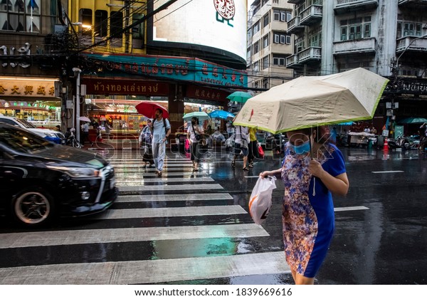 Bangkok, Chinatown -\
8/14/20: Commuters armed with umbrellas leave work in the rain in\
Bangkok\'s Chinatown. 