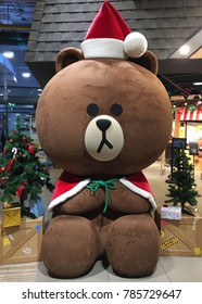 BANGKOK - DECEMBER 13, 2017: A Big Brown Bear In Santa Claus's Dress Near The Line Village Store Located In The Siam Paragon Mall. It Is One Of The Biggest Shopping Centres In Asia.