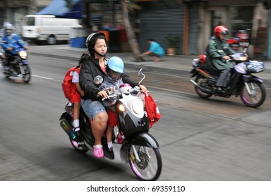 BANGKOK - JAN 12: Unidentified Family School Run On A Motorbike During The Morning Rush Hour On Jan 12, 2011 In Bangkok, Thailand. The Use Of Motorbikes As Family Transport Is Commonplace In Thailand.