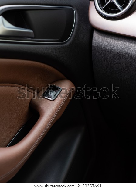 BANGKOK - Jan 22, 2022 : Inner car door handle for\
a front seat of a BENZ B180 model, showing left side door control\
buttons for an easy control with modern design, seeing from a back\
seat.