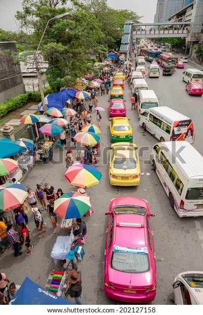 BANGKOK - JUNE 28:Cars, buses, taxis and people crowd on\
street at Chatuchak market Bangkok on June 28,2014.Chatuchak/JJ is\
the largest market in Thailand and the world\'s largest weekend\
market. 