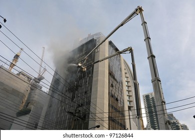 BANGKOK - MAR 5: Firefighters tackle a blaze at Fico Building on Asoke Road in the city centre on Mar 5, 2012 in Bangkok, Thailand. The BMA has launched an investigation in the cause of the blaze. - Shutterstock ID 97126844