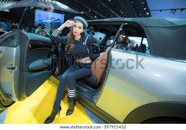 BANGKOK - March 26, 2016 :\
Unidentified model with Mini car on display at the 37th BANGKOK\
INTERNATIONAL MOTOR SHOW 2016 on March 26, 2016 in Bangkok,\
Thailand. 