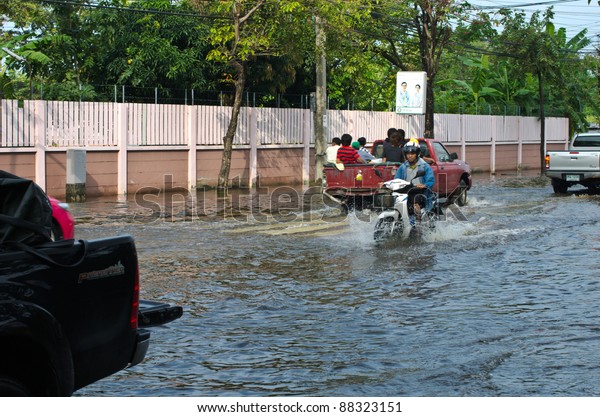 BANGKOK -\
NOVEMBER 7: Car and Motorcycle navigating through the flood after\
the heaviest monsoon rain in 20 years in the capital  on November\
7, 2011  Nuan Chan Road, bangkok,\
Thailand.