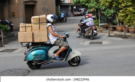 BANGKOK - OCT 26: A motorcycle courier rides an overloaded Vespa on a city street on Oct 26, 2011 in Bangkok, Thailand. The use of motorcycles to transport goods is commonplace in Bangkok.
