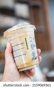 Bangkok, Samut Prakan - May 22, 2022 : Holding a cup of Almondmilk White Chocolate Affogato Frappuccino from Starbucks coffee. Starbucks is the world's largest coffeehouse and is highly popular