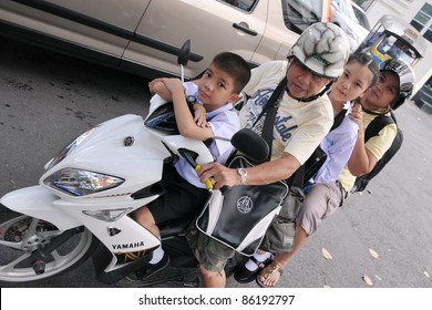 BANGKOK - SEPT 12: Unidentified Family Make A School Run By Motorbike During Evening Rush Hour On Sept 12, 2011 In Bangkok, Thailand. The Use Of Motorbikes As Family Transport Is Commonplace In Thailand.