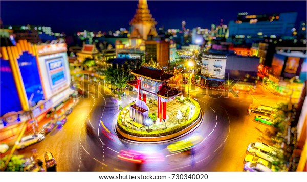 Bangkok skyline at sunset and China Gate at the\
entrance to Chinatown in Bangkok, Thailand (logos blurred for\
commercial use)