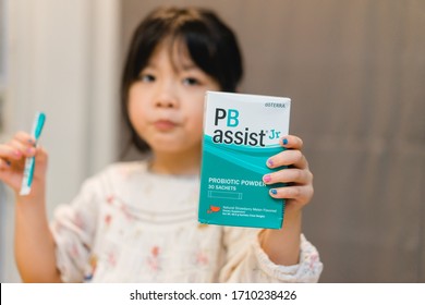 Bangkok / Thailand - 04 19 2020 :Little Girl Eat PB Assist Jr Is A Powdered Probiotic Supplement Designed For Children Or Adults Who Have Trouble Swallowing Pills.doTTERA Products From UTAH.