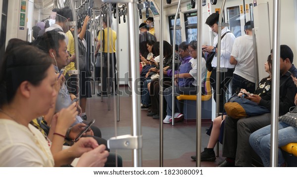 BANGKOK, THAILAND - 10 JULY, 2019: Asian\
passengers in train using smartphones. Thai people online surfing\
internet in bts car. Public transportation. Addiction from social\
media and phone in\
subway