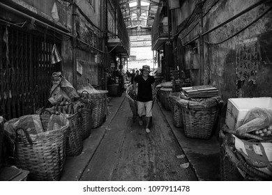 Bangkok / Thailand- 11.9.2014 : A Vegetable Market Vendor Is Passing With His Trolley  In A Dark Alley 