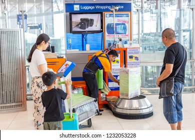 Bangkok, Thailand - 21 July 2018 - Luggage Wrapping Service staff wraps customer box while they wait at Suvannaphumi International Airport in Bangkok, Thailand on July 21, 2018