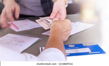 Bangkok, Thailand (27 Oct 18) - Asian Old Woman Is Making Payment To Vehicle Inspection Service Center For Their Car Checking Service And Insurance Policy For Further Annual License Plate Renewal