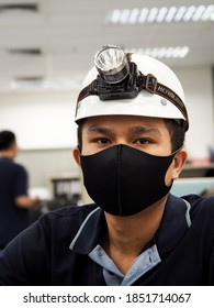 Bangkok Thailand, 29/06/2020, Portrait Of An Asian Man Working As A Technician Wearing A Black Mask Wear A White Safety Hat And A Headlamp. Get Ready To Go To Work
