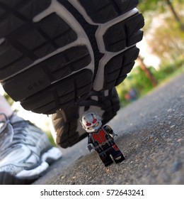 Bangkok, Thailand: 5 Feb 2017 - Lego Ant-man running away from human foot. This mini figure is from Marvel super heroes sets. Lego is a brick brand by Lego group.