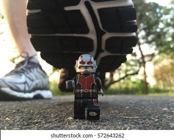 Bangkok, Thailand: 5 Feb 2017 - Lego Ant-man running away from human foot. This mini figure is from Marvel super heroes sets. Lego is a brick brand by Lego group.