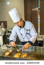 Bangkok, Thailand - 7 May 2016 - Female Chef Seasons Delicious Chicken Teriyaki To Serve The Customer In A Teppanyaki Kitchen.