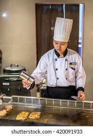 Bangkok, Thailand - 7 May 2016 - Female Chef Seasons Delicious Chicken Teriyaki To Serve The Customer In A Teppanyaki Kitchen.