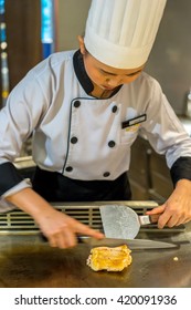 Bangkok, Thailand - 7 May 2016 - Female Chef Slices Delicious Chicken Teriyaki To Serve The Customer In A Teppanyaki Kitchen.