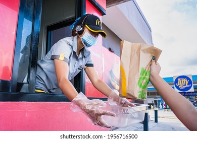 Bangkok, Thailand- April, 03, 2021 : Female Staff At McDonald's Deliver Food To Customers Through The Door Of The Car At The Pick Up Point In Bangkok, Thailand