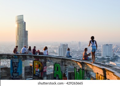 BANGKOK, THAILAND - APRIL 04, 2015: tourists partying on the rooftop of the building in bkk on a foggy evening in sunset