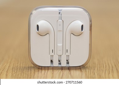 BANGKOK THAILAND APRIL 17 2015: Close Up Image Of Apple Ear Pods On The Wooden Table On April 17,  2015 In Bangkok Thailand