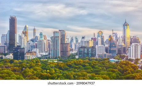 BANGKOK, THAILAND - APRIL 17, 2021 : beautiful panoramic view of Bangkok central business  district cityscape with foreground of greenery Lumphini Park view