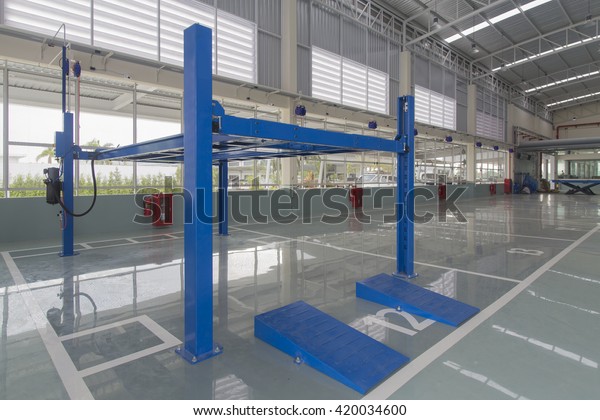 Bangkok, Thailand APRIL 2016:traffic symbol on new epoxy\
floor at factory building and Blue lift in the car-care\
workshop.New epoxy floor\
