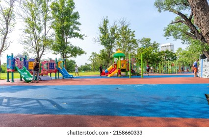Bangkok, Thailand - April 24, 2022 : Children and family happily have fun at playground in public park in Bangkok, Thailand on April 24, 2022.