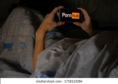 Bangkok, Thailand- April 29, 2020. Closeup of hand using Mobile Device showing Porn Hub logo at night. Ready to watch porn videos.