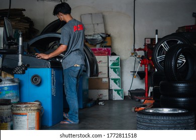 Bangkok, Thailand - April 4, 2020 : Unidentified Car Mechanic Or Serviceman Wheel Alignment And Tire Balance Checking Car Wheel For Fix And Repair Suspension Problem At Car Garage Or Repair Shop