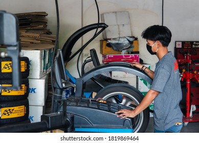 Bangkok, Thailand - April 4, 2020 : Unidentified Car Mechanic Or Serviceman Wheel Alignment And Tire Balance Checking Car Wheel For Fix And Repair Suspension Problem At Car Garage Or Repair Shop