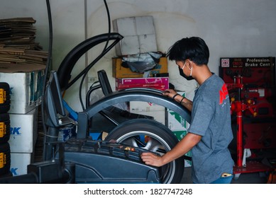 Bangkok, Thailand - April 4, 2020 : Unidentified Car Mechanic Or Serviceman Wheel Alignment And Tire Balance Checking Car Wheel For Fix And Repair Suspension Problem At Car Garage Or Repair Shop