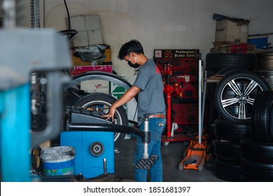 Bangkok, Thailand - April 4, 2020 : Unidentified Car Mechanic Or Serviceman Wheel Alignment And Tire Balance Checking Car Wheel For Fix And Repair Suspension Problem At Car Garage Or Repair Shop