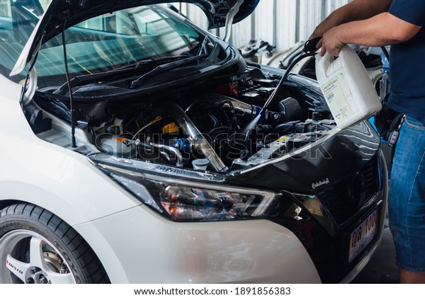 Bangkok,\
Thailand - April 4, 2020 : Unidentified car mechanic or serviceman\
cleaning the car engine after checking a car engine for fix and\
repair problem at car garage or repair\
shop